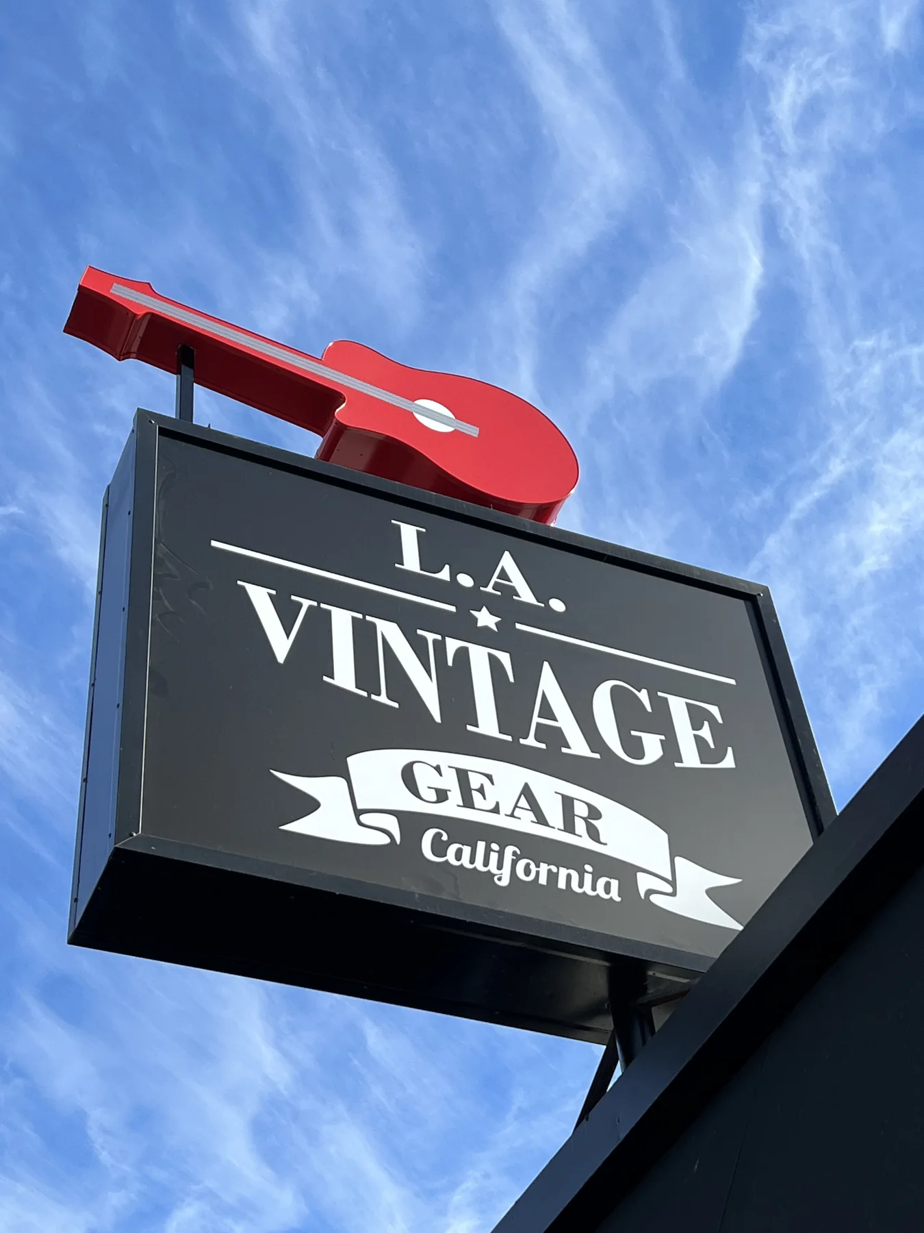 L.A. Vintage Gear street sign with its red guitar against a blue sky